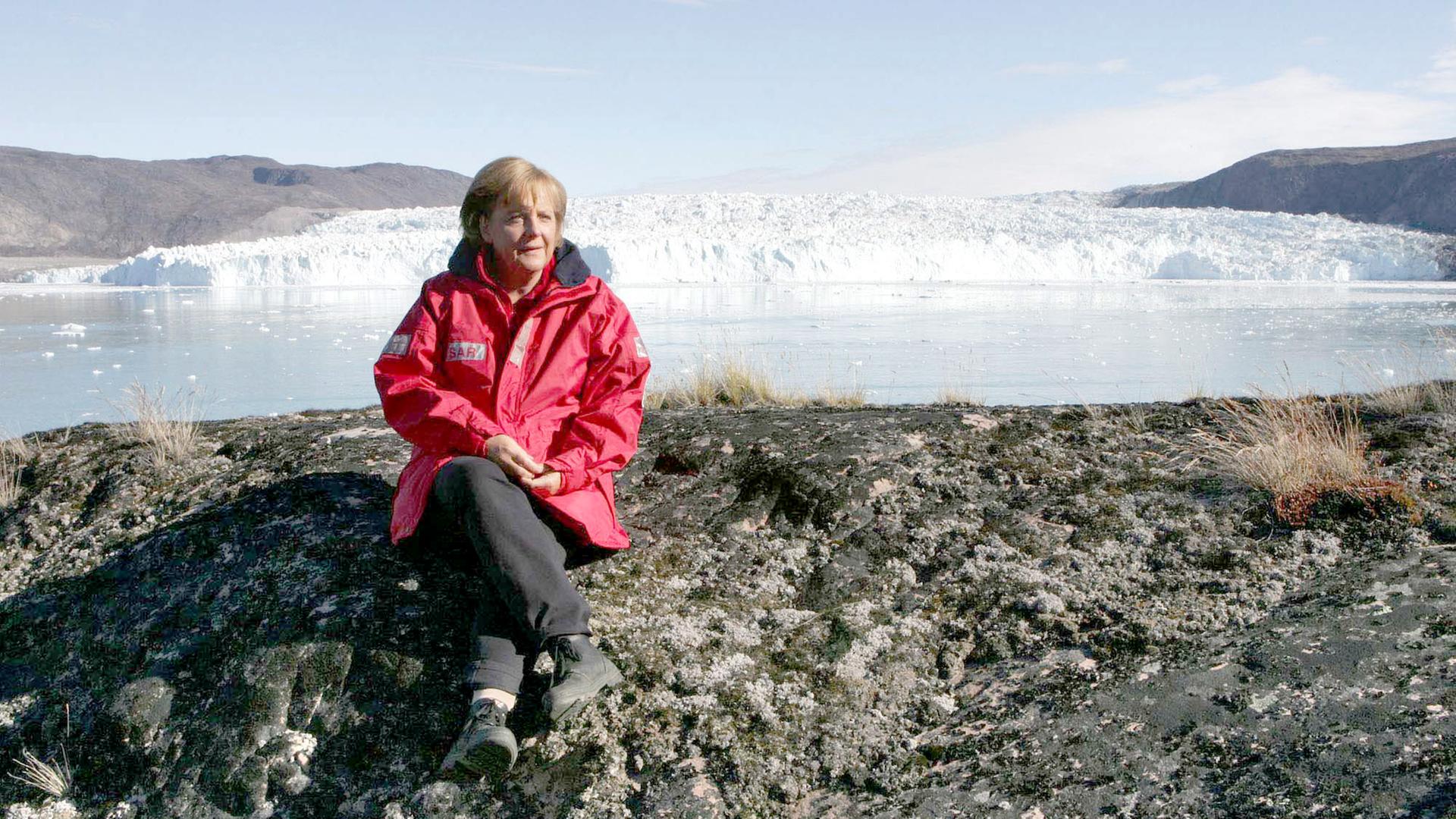 Angela Merkel sitzt auf einem Gletscher in Grönland.