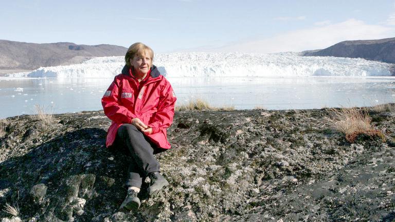 Angela Merkel sitzt auf einem Gletscher in Grönland.
