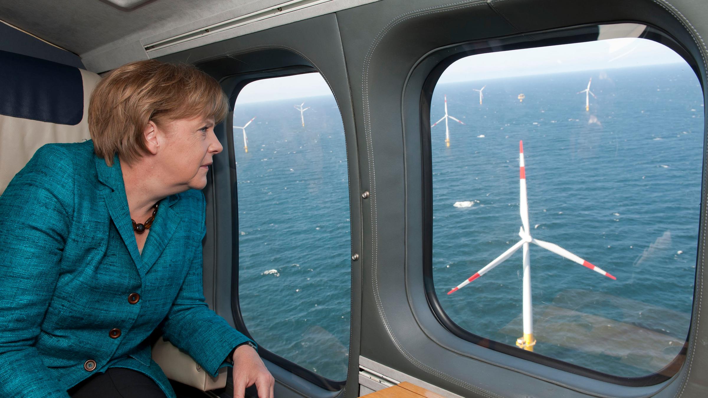 Merkel schaut aus dem Flugzeug auf einen Windpark