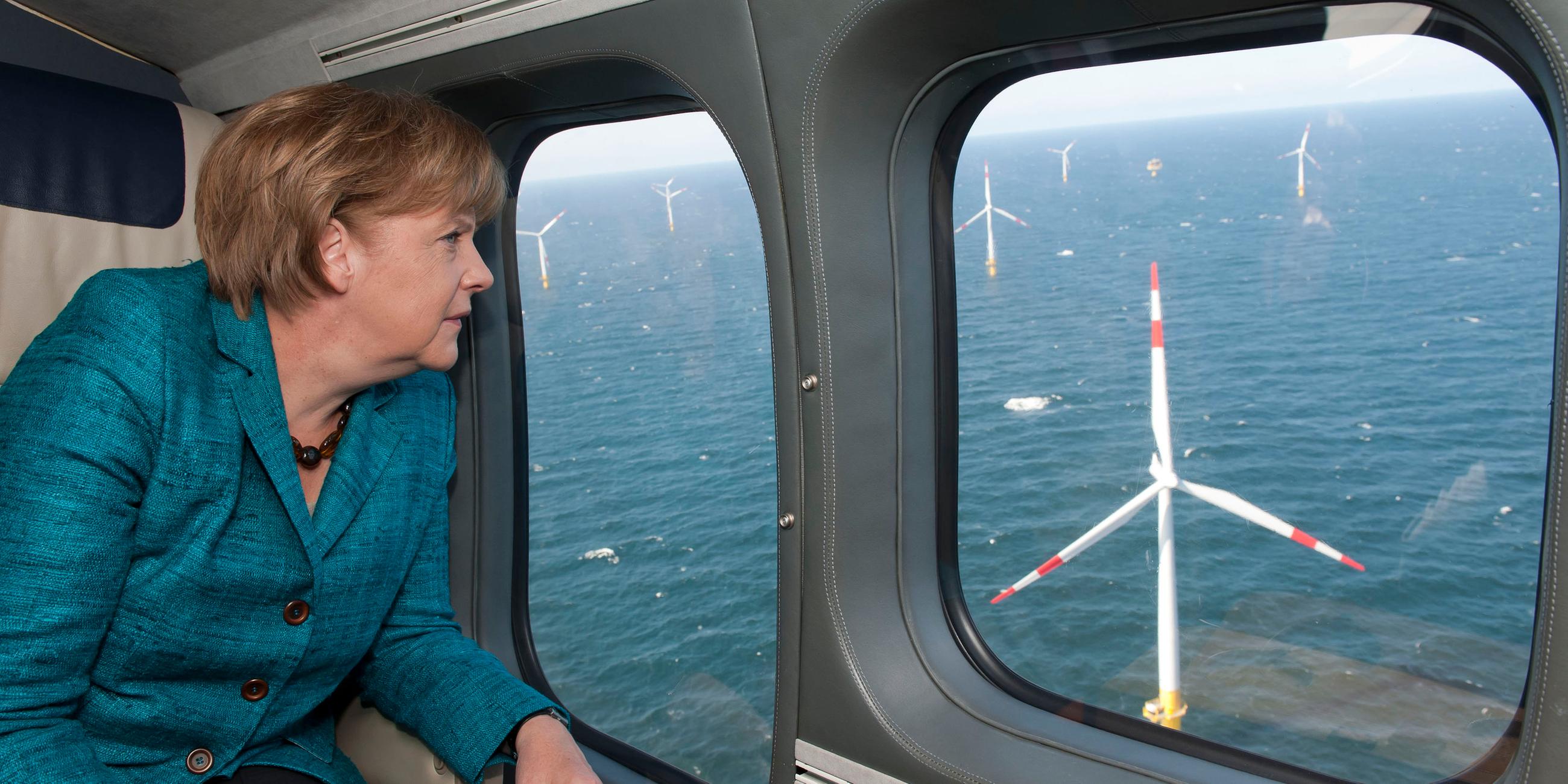 Merkel schaut aus dem Flugzeug auf einen Windpark