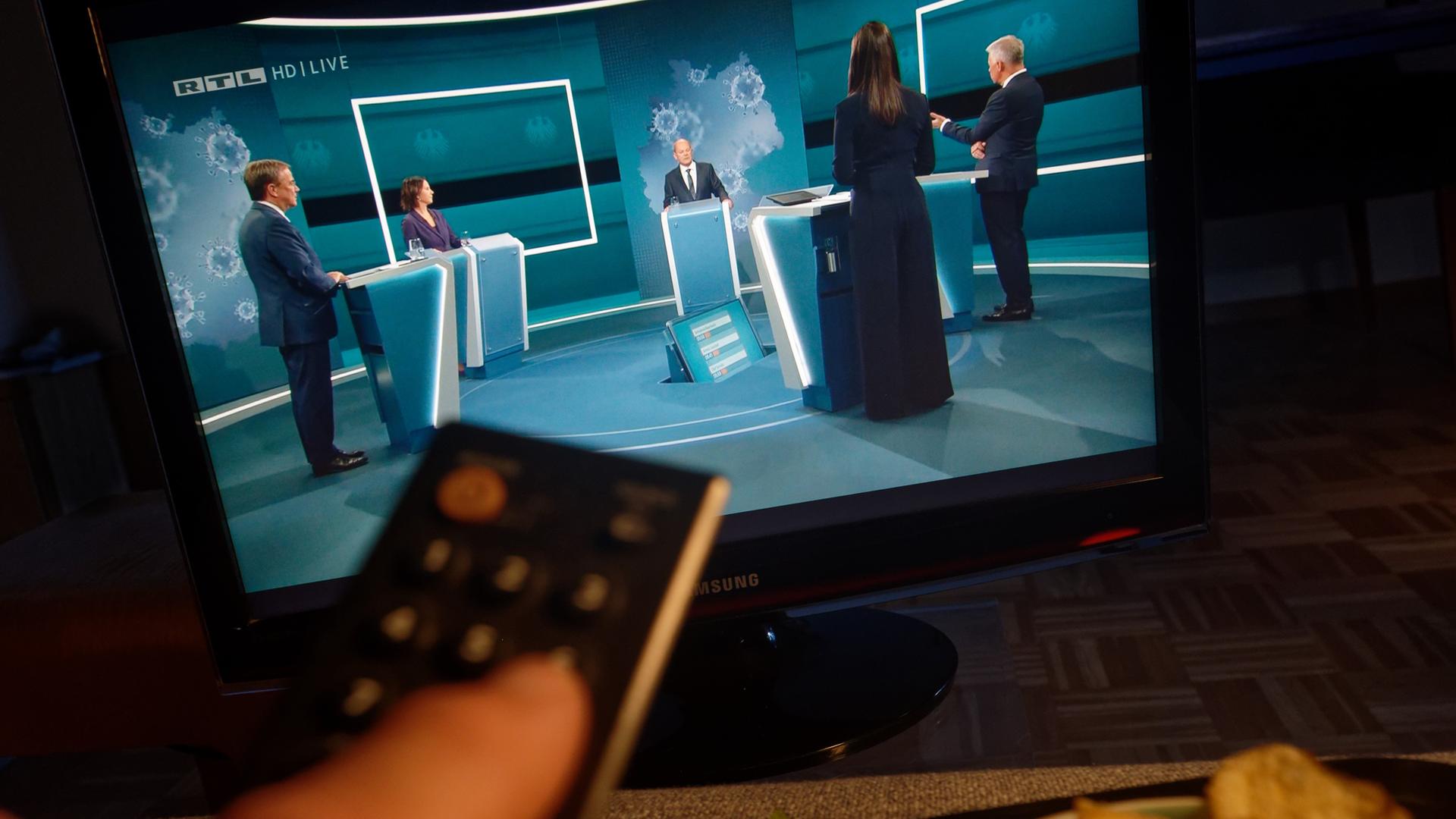 Auf einem Fernseher in einem Wohnzimmer ist "Das Triell" im Fernsehprogramm RTL zu sehen.