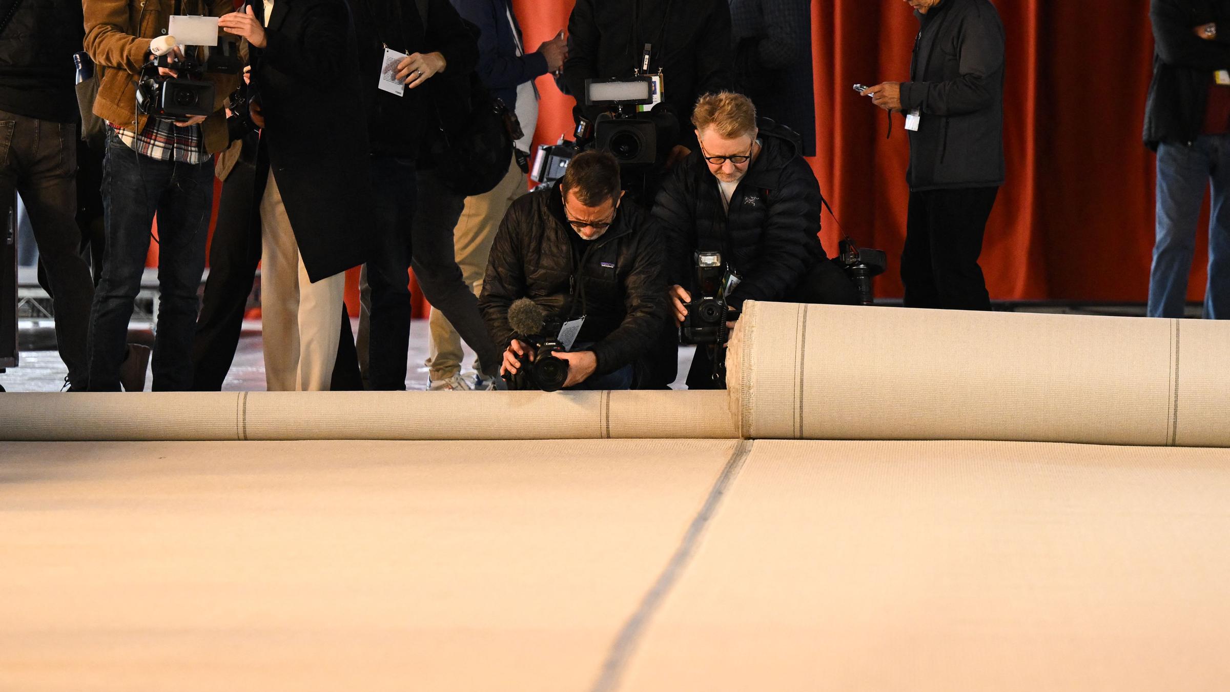 Das Personal rollt den beigen Teppich für die Oscar-Verleihung aus. 