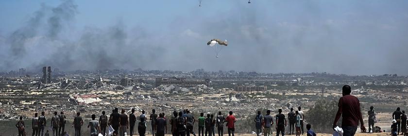 Nusairat, Gazastreifen, Palästinensisches Gebiet: Palästinenser eilen zum Ort des Geschehens, als Luftpaletten mit humanitären Hilfsgütern über Nuseirat im zentralen Gazastreifen aus einem Militärflugzeug abgeworfen werden und mit Fallschirmen herabgleiten. Dies geschieht im Rahmen einer Luftabwurfmission über dem von Israel belagerten palästinensischen Gebiet am 5. August 2025.