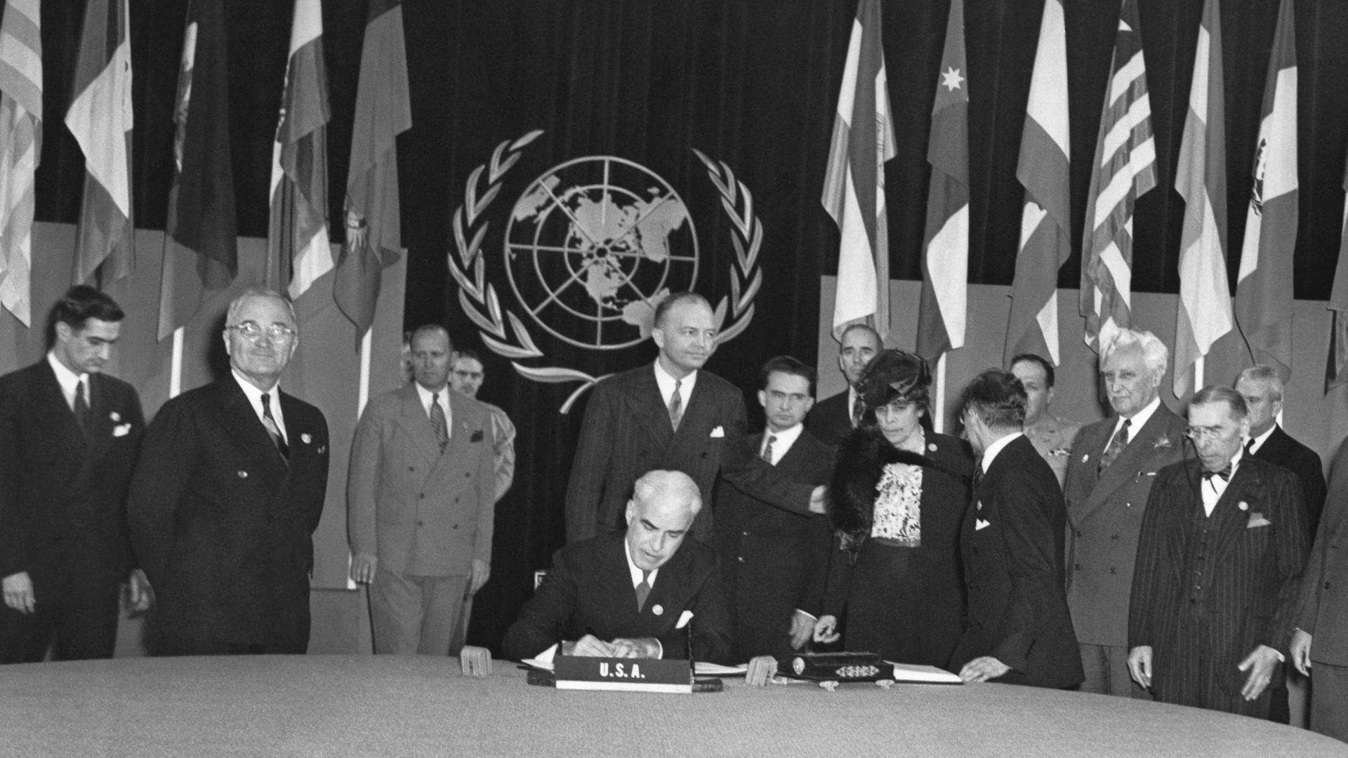 Archiv: US-Präsident Truman (zweiter von links) sieht stolz zu, wie US-Außenminister Edward Stettinus die Charta der Vereinten Nationen am 26.06.1945 unterzeichnet.