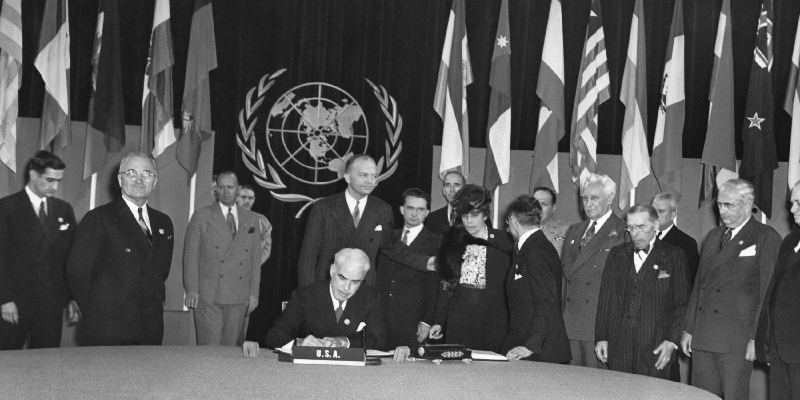 Archiv: US-Präsident Truman (zweiter von links) sieht stolz zu, wie US-Außenminister Edward Stettinus die Charta der Vereinten Nationen am 26.06.1945 unterzeichnet.