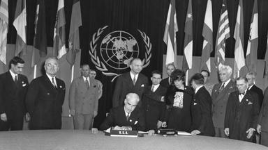 Archiv: US-Präsident Truman (zweiter von links) sieht stolz zu, wie US-Außenminister Edward Stettinus die Charta der Vereinten Nationen am 26.06.1945 unterzeichnet.