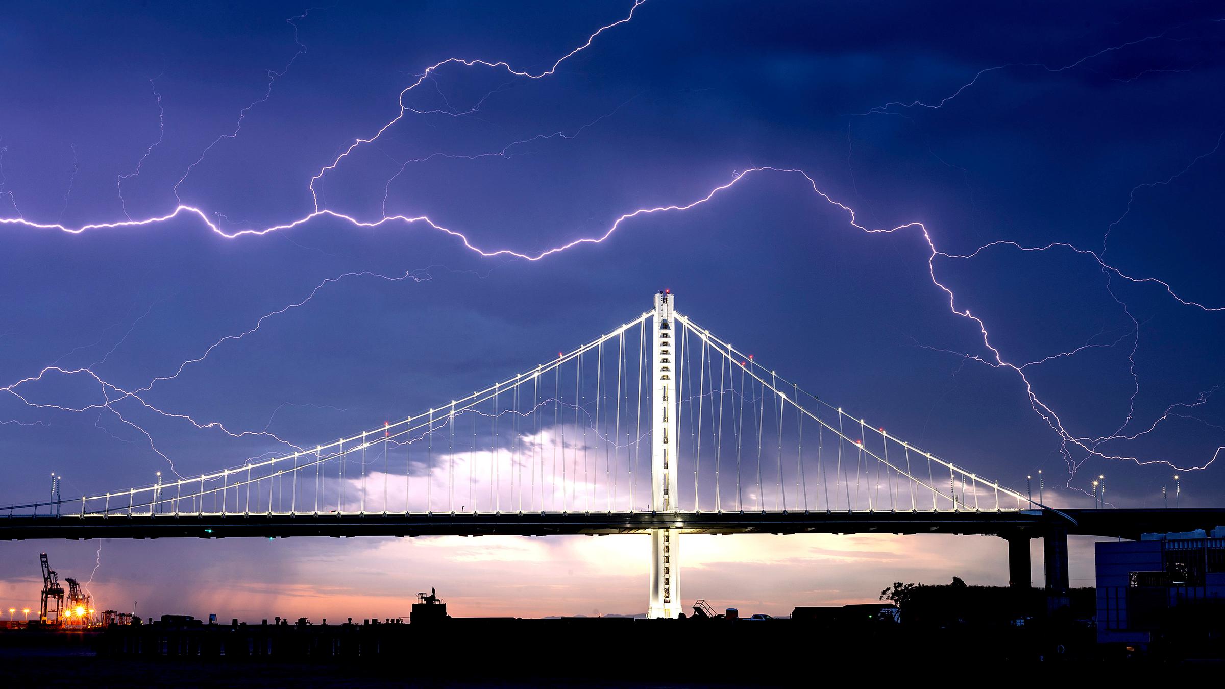 Auf dem Bild ist die Golden Gate Bridge von Blitzen umgeben