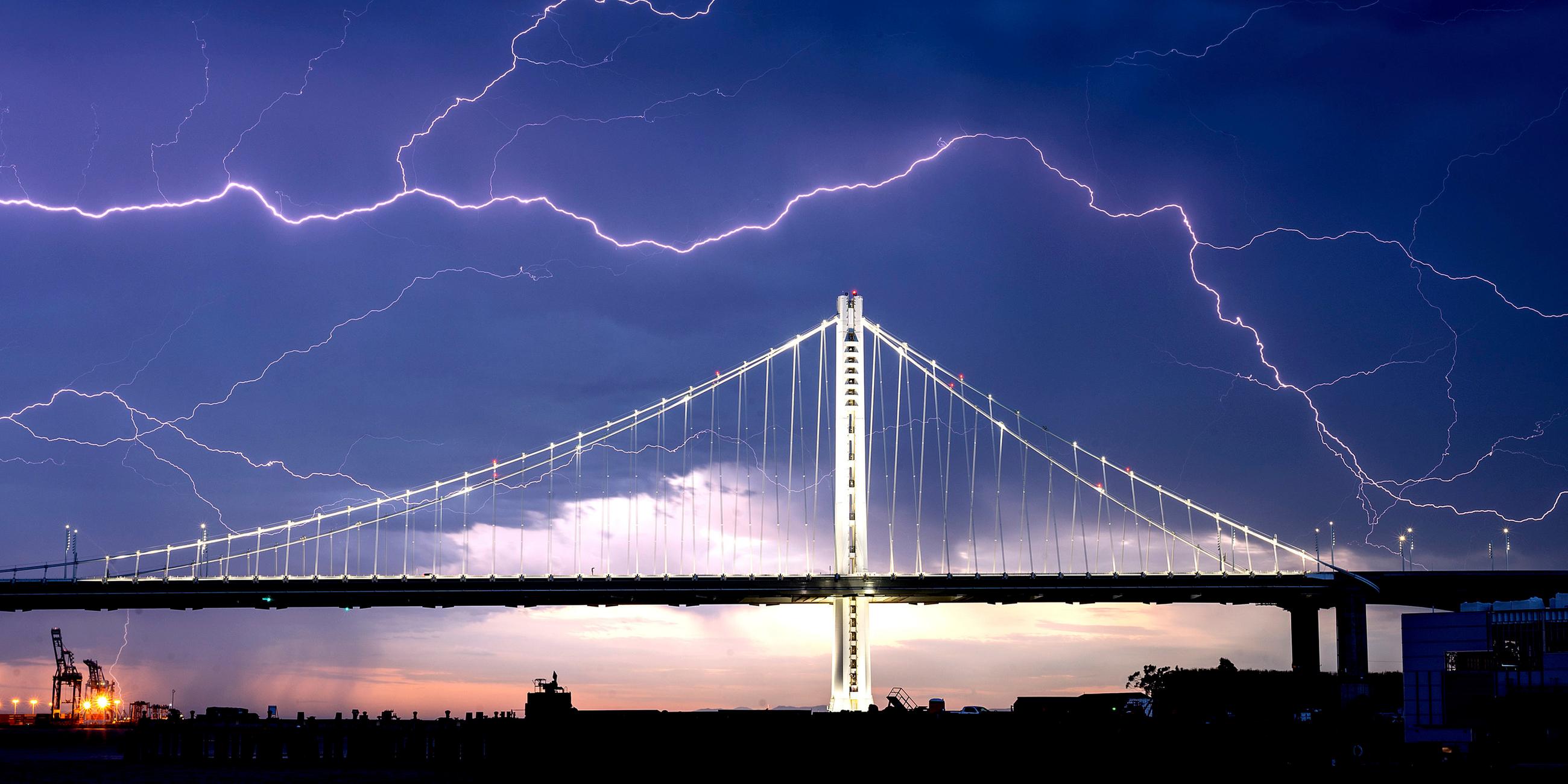 Auf dem Bild ist die Golden Gate Bridge von Blitzen umgeben