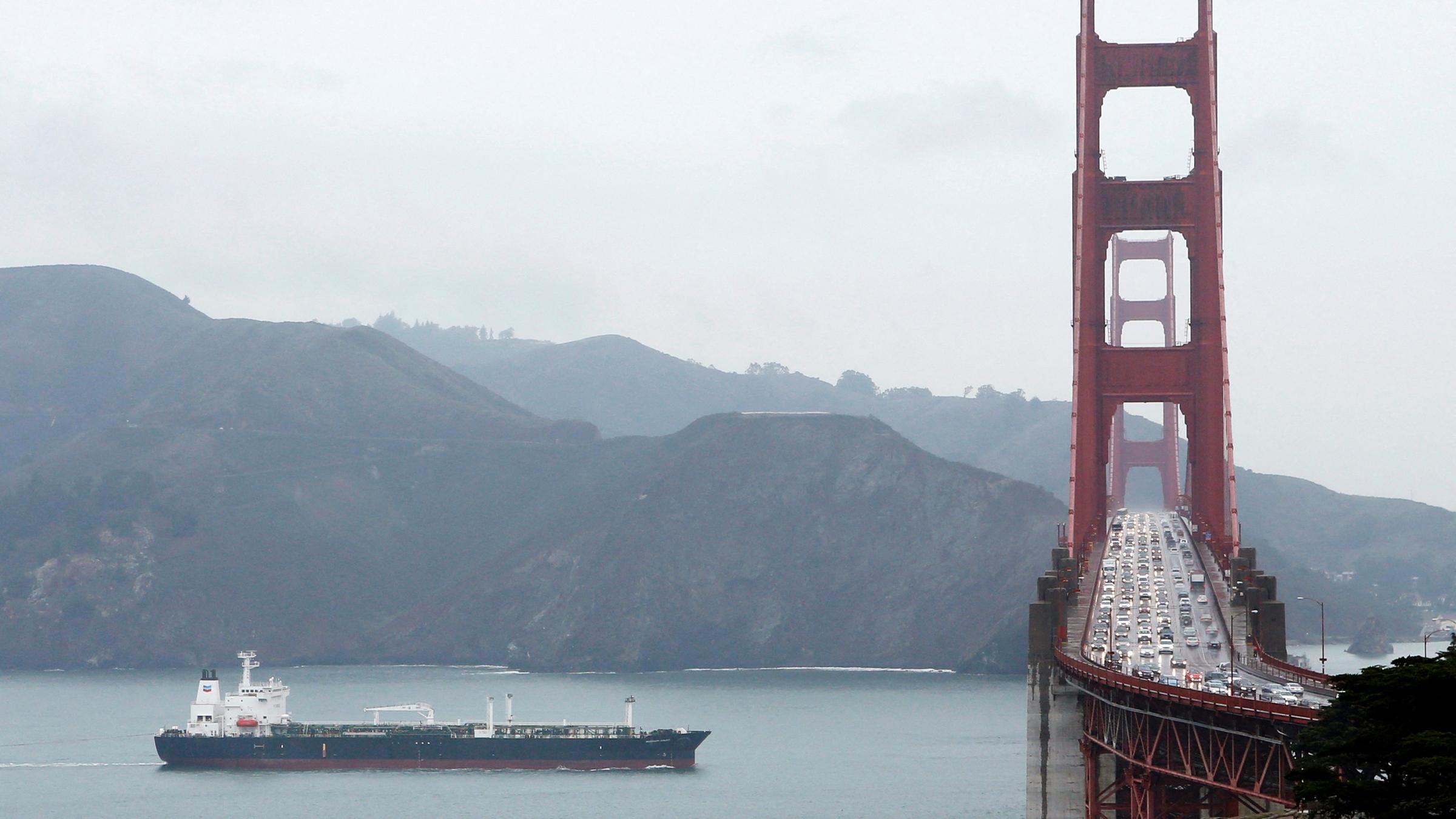 Auf der Brücke durchquert ein Schiff die Golden Gate Bridge.
