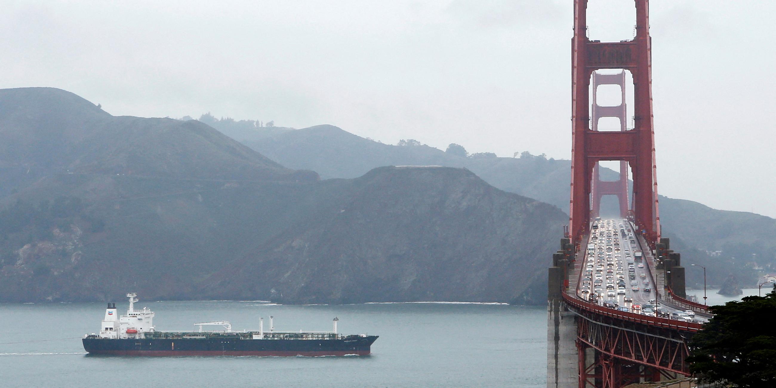 Auf der Brücke durchquert ein Schiff die Golden Gate Bridge.