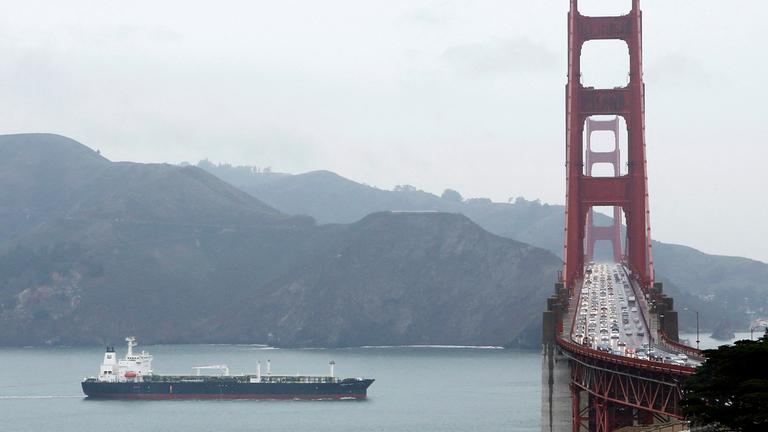 Auf der Brücke durchquert ein Schiff die Golden Gate Bridge.