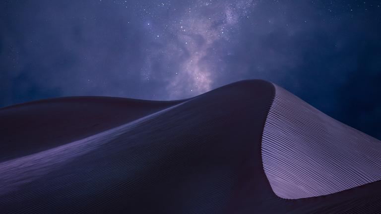 Vom Licht lila gefärbter Sand in der Wüste Omans