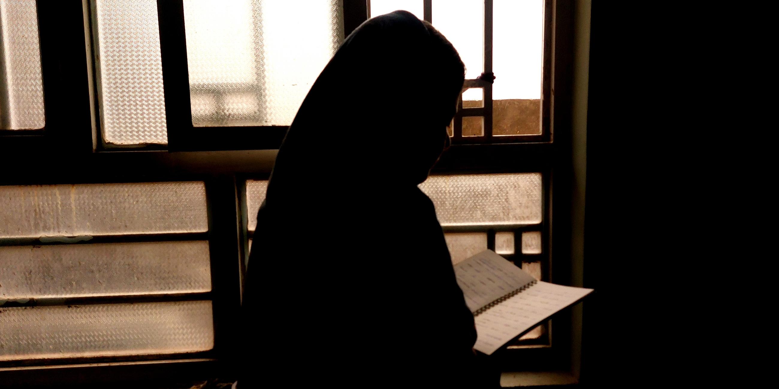 Mädchen mit Kopftuch liest Buch