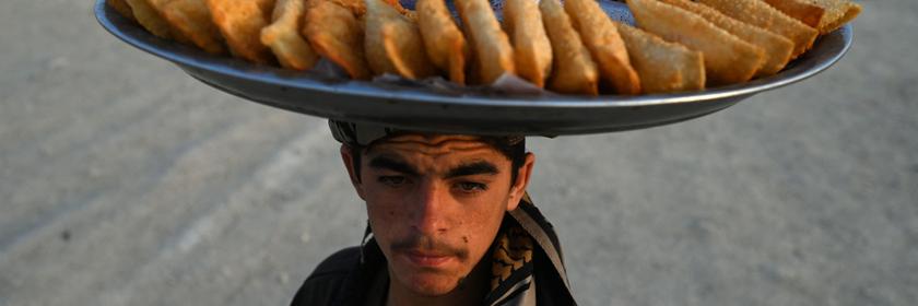 Mann trägt eine Platte mit Samosas auf dem Kopf