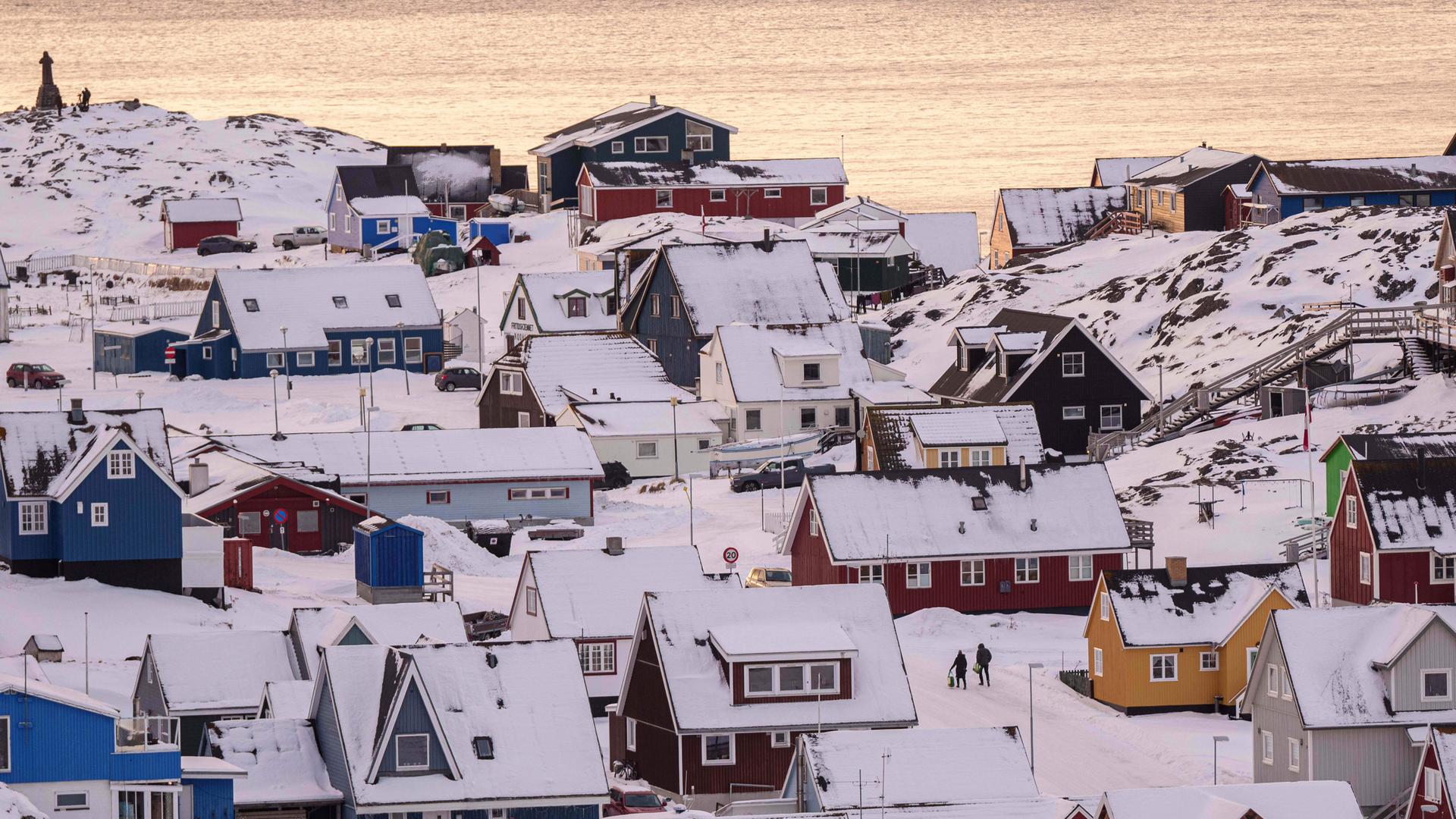 14.01.2026, Grönland, Nuuk: Menschen gehen auf einer Straße der Stadt. Foto: Evgeniy Maloletka/AP/dpa +++ dpa-Bildfunk +++