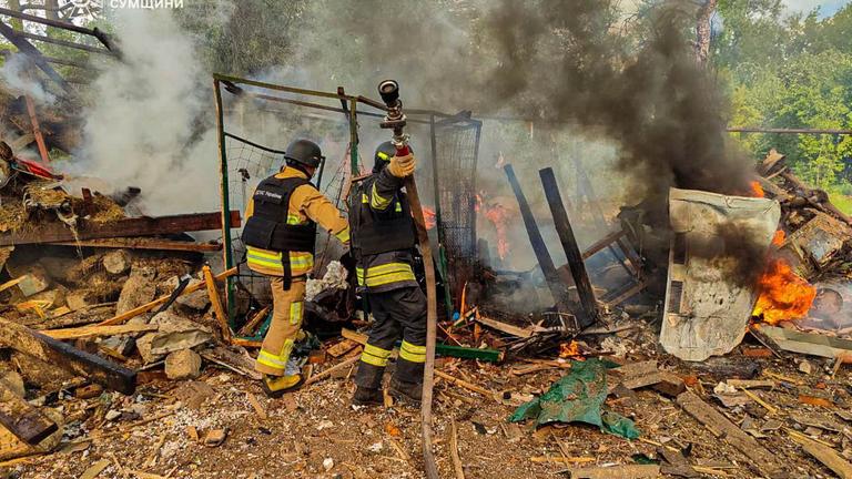 Feuerwehrleute löschen einen Brand nach einem Angriff auf ein Dorf in Sumy im April.