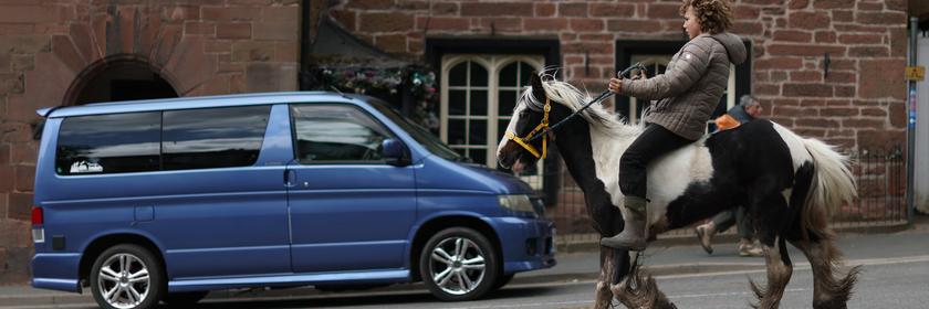 Ein schwarz-weiß geflecktes Pferd wird durch eine Straße in Appleby geritten. 