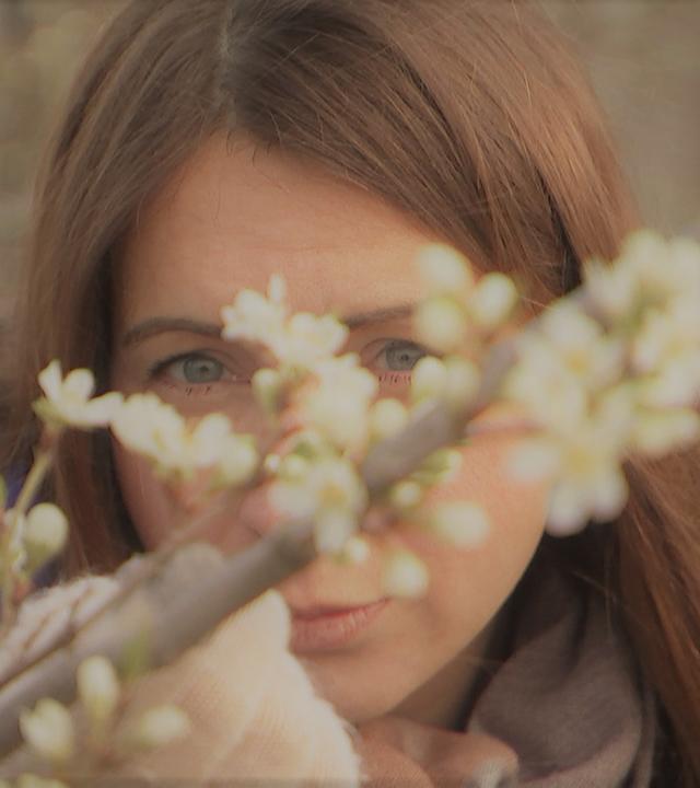 Magdalena versteckt hinter einem blühenden Zweig