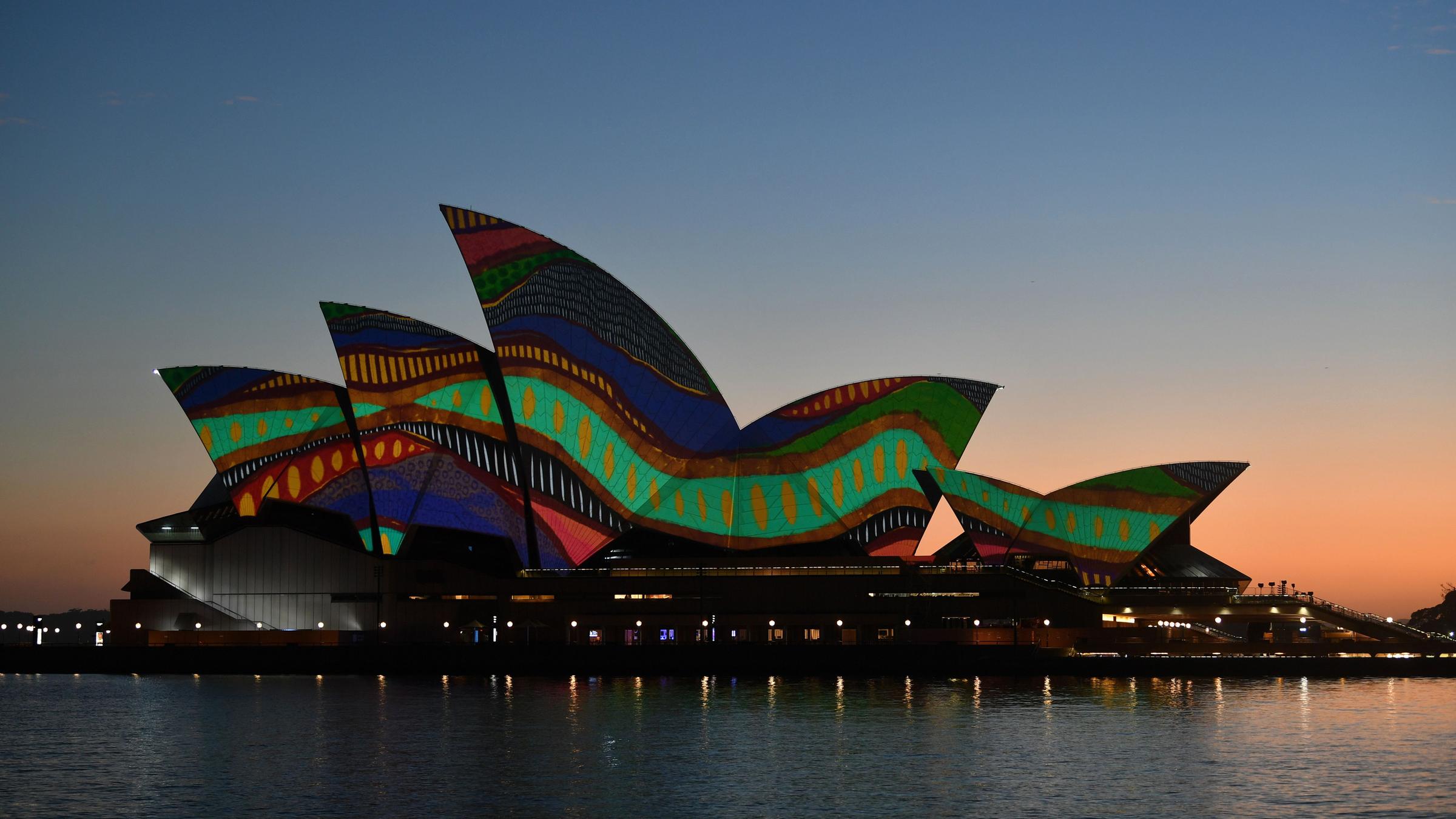 Das berühmte Opernhaus in Sydney ist in traditionellen Mustern der Aborigines angestrahlt.