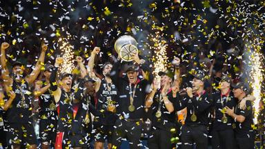 Deutschlands Cheftrainer Alex Mumbru hebt den Pokal und feiert mit seinen Spielern den EM-Sieg.