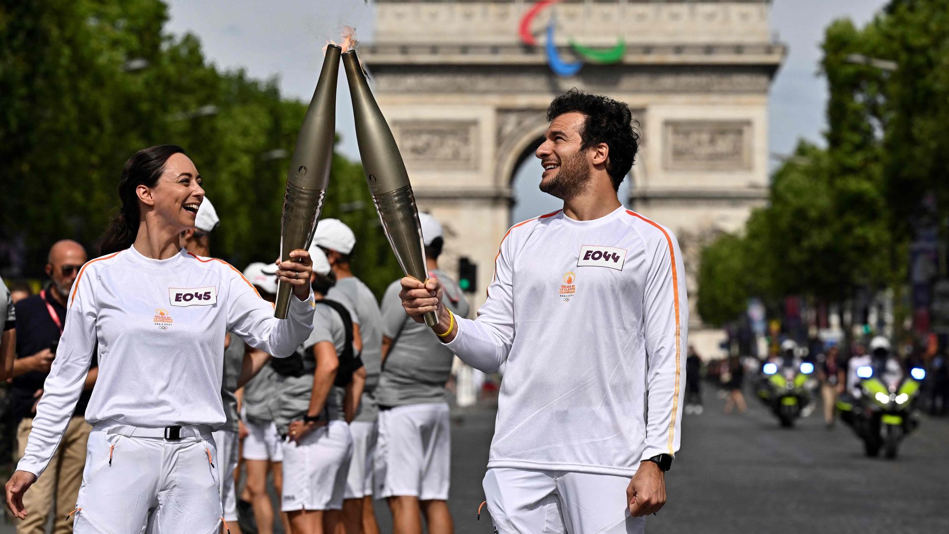 Fackelübergabe der olympischen Flamme auf der Avenue des Champs Élysées.
