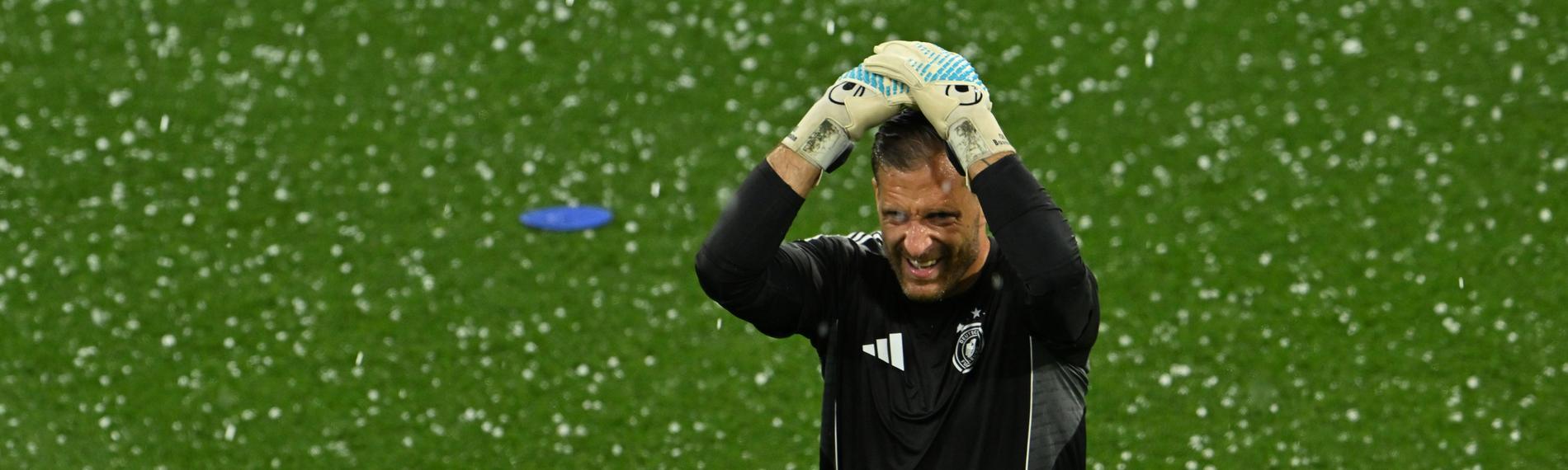 Oliver Baumann, Torhüter von Deutschland, schützt seinen Kopf mit den Händen vor den herabfallenden Hagelkörnern im Stadion