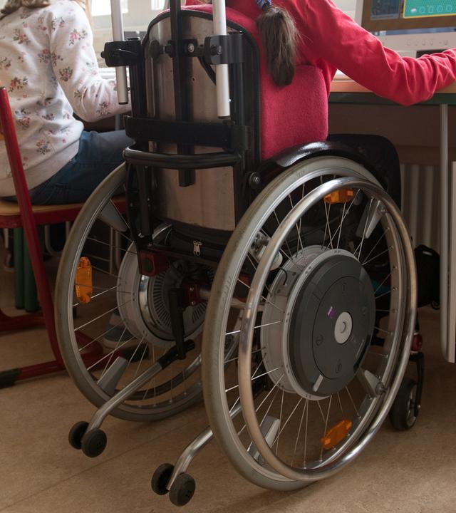 Zum Tag der Menschen mit Behinderung: Kind im Rollstuhl in der Schule