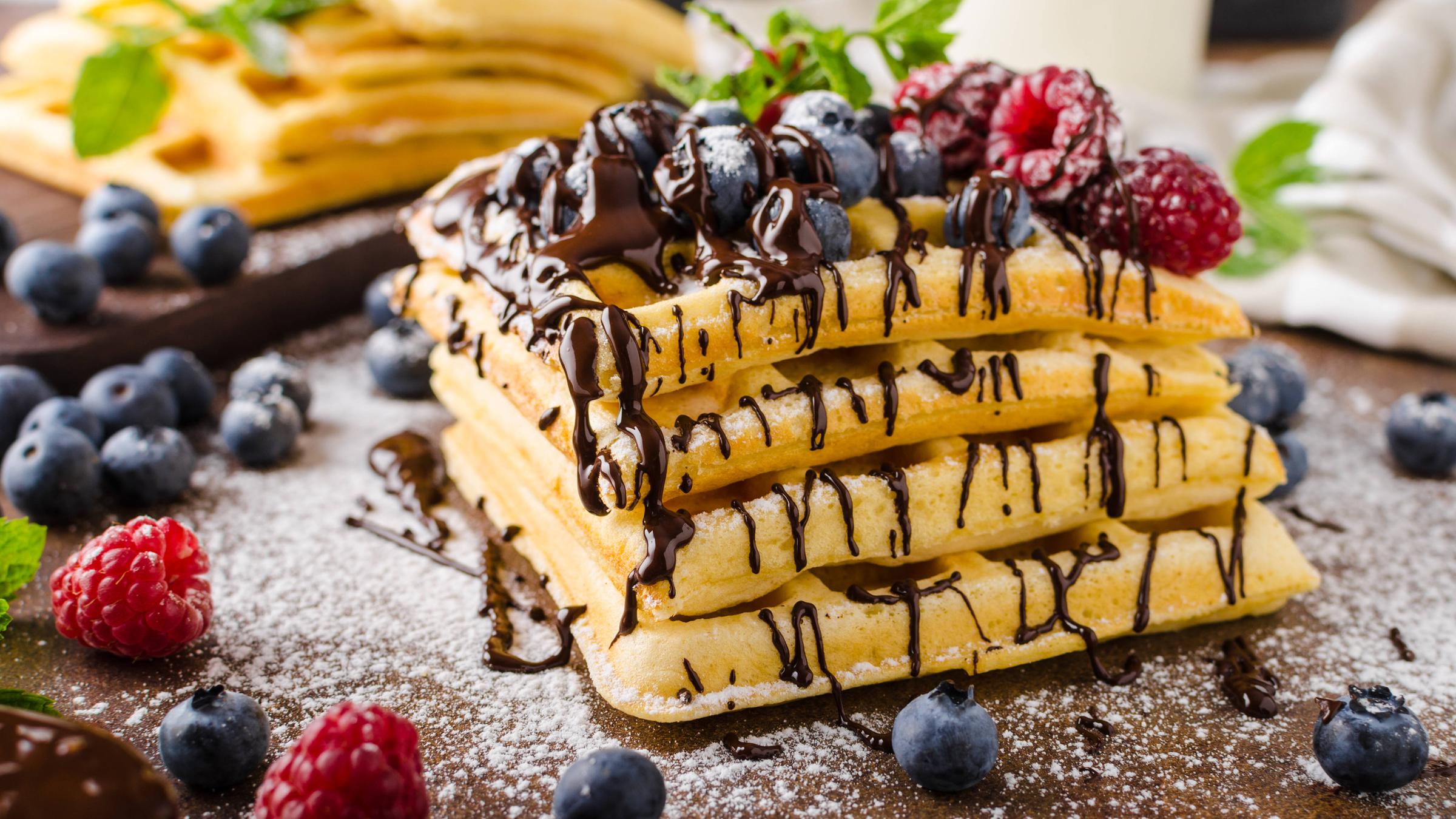 Belgische Waffeln auf einem Stapel mit Schokolade und Früchten