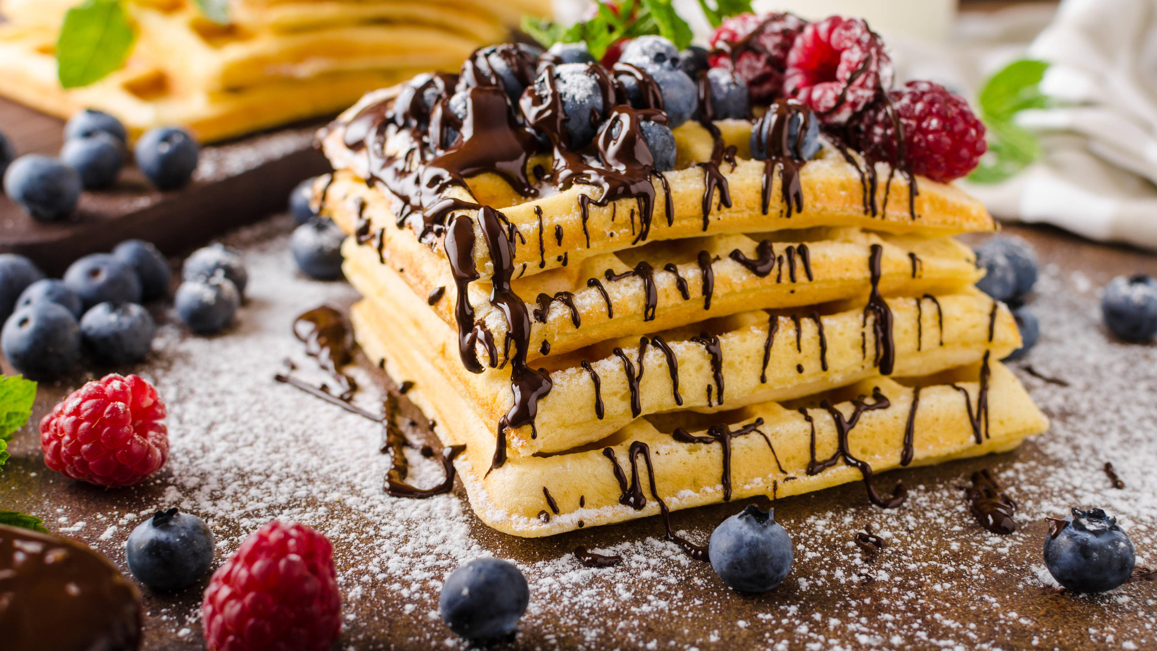 Belgische Waffeln auf einem Stapel mit Schokolade und Früchten