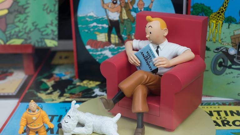 Tim, von Tim und Struppi sitzt auf deinem Sessel inmitten der Comic-Hefte