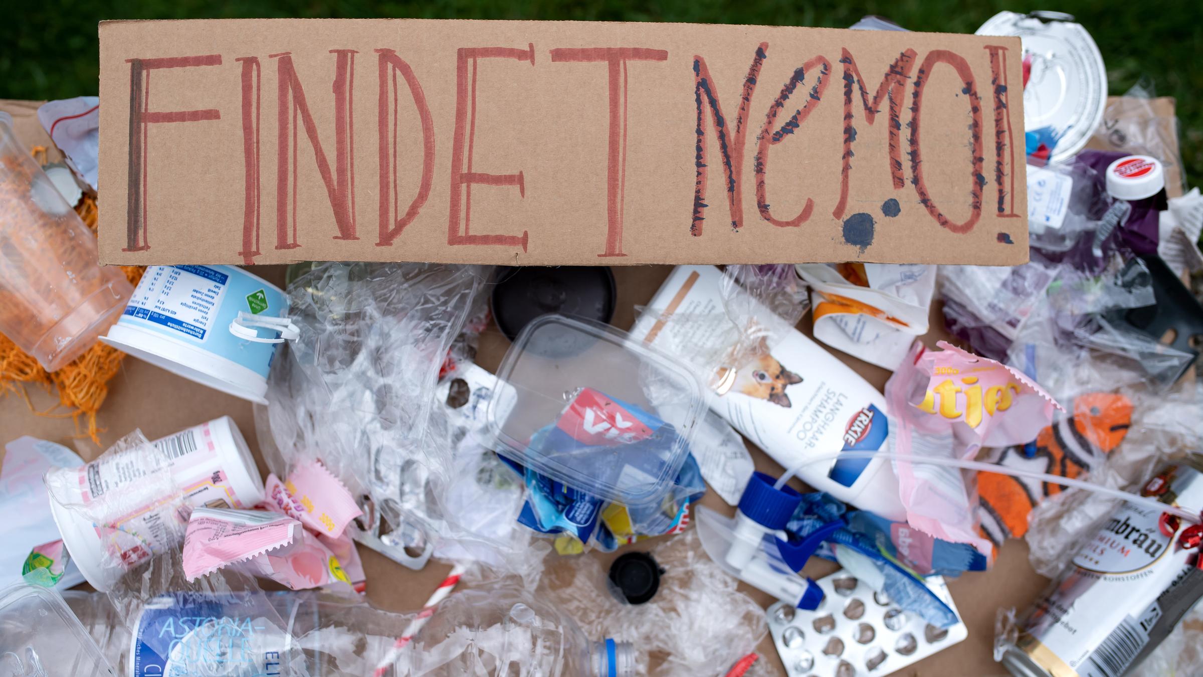 Ein Plakat mit aufgeklebtem Plastikmüll und der Aufschrift "Findet Nemo" 