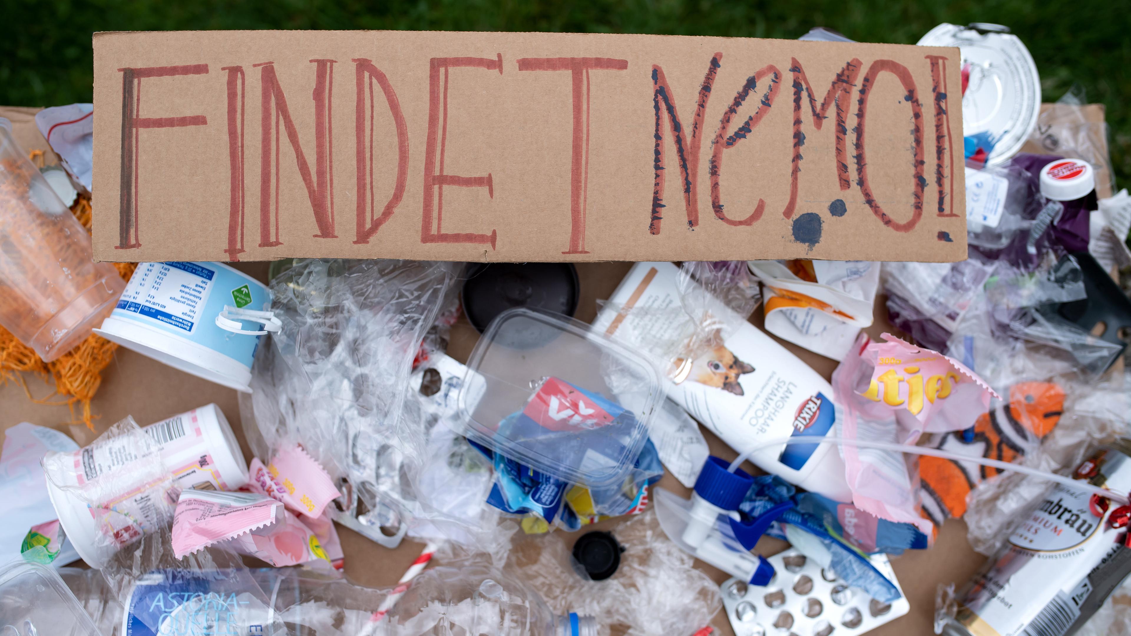 Ein Plakat mit aufgeklebtem Plastikmüll und der Aufschrift "Findet Nemo" 