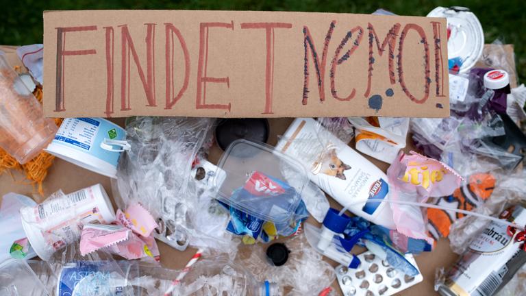 Ein Plakat mit aufgeklebtem Plastikmüll und der Aufschrift "Findet Nemo" 