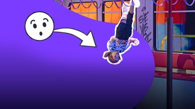 Ein Junge hängt kopfüber mit den Füßen in den Halteschlaufen in einem U-Bahn-Waggon. 