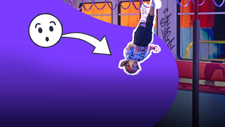 Ein Junge hängt kopfüber mit den Füßen in den Halteschlaufen in einem U-Bahn-Waggon. 