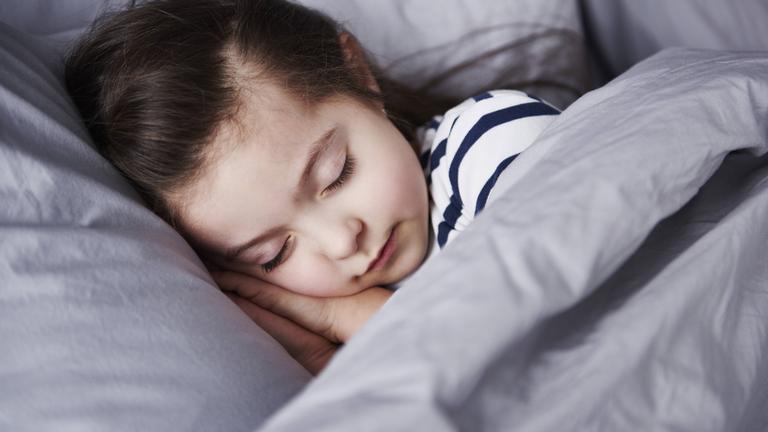 Mädchen schläft im Bett