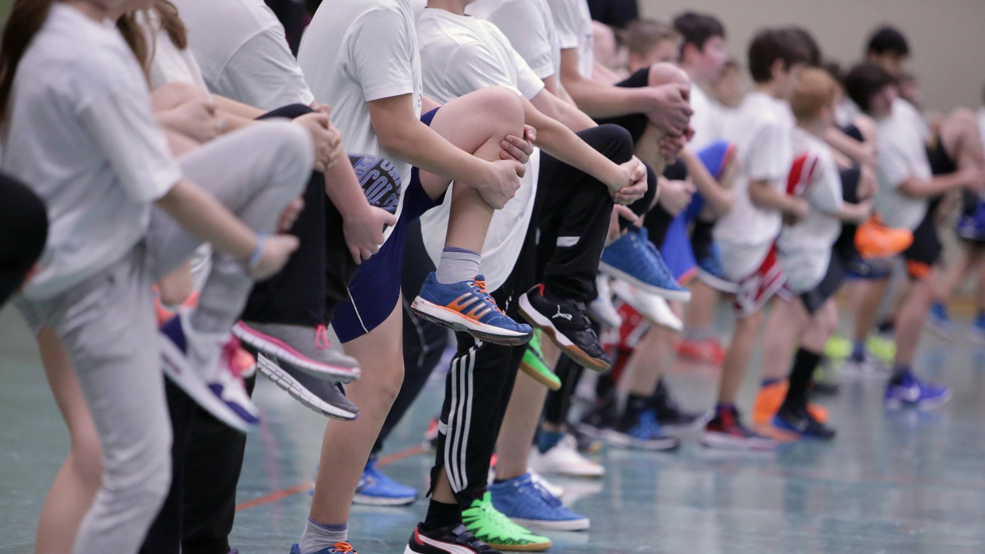 Schüler dehnen sich beim Schulsport.