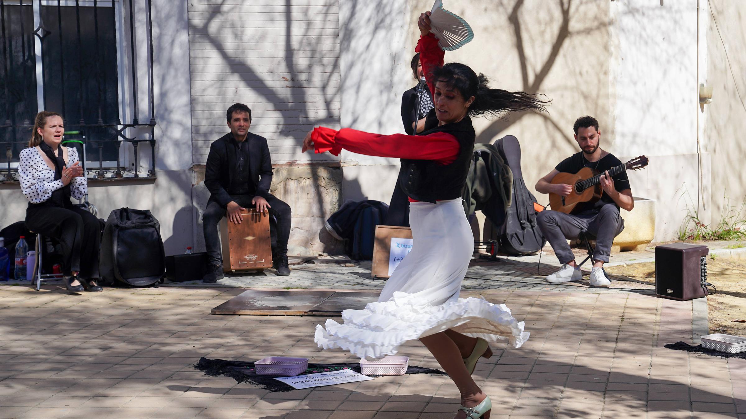 Eine Flamenco-Tänzerin tanzt und hebt dabei ihren Arm mit einem Fächer