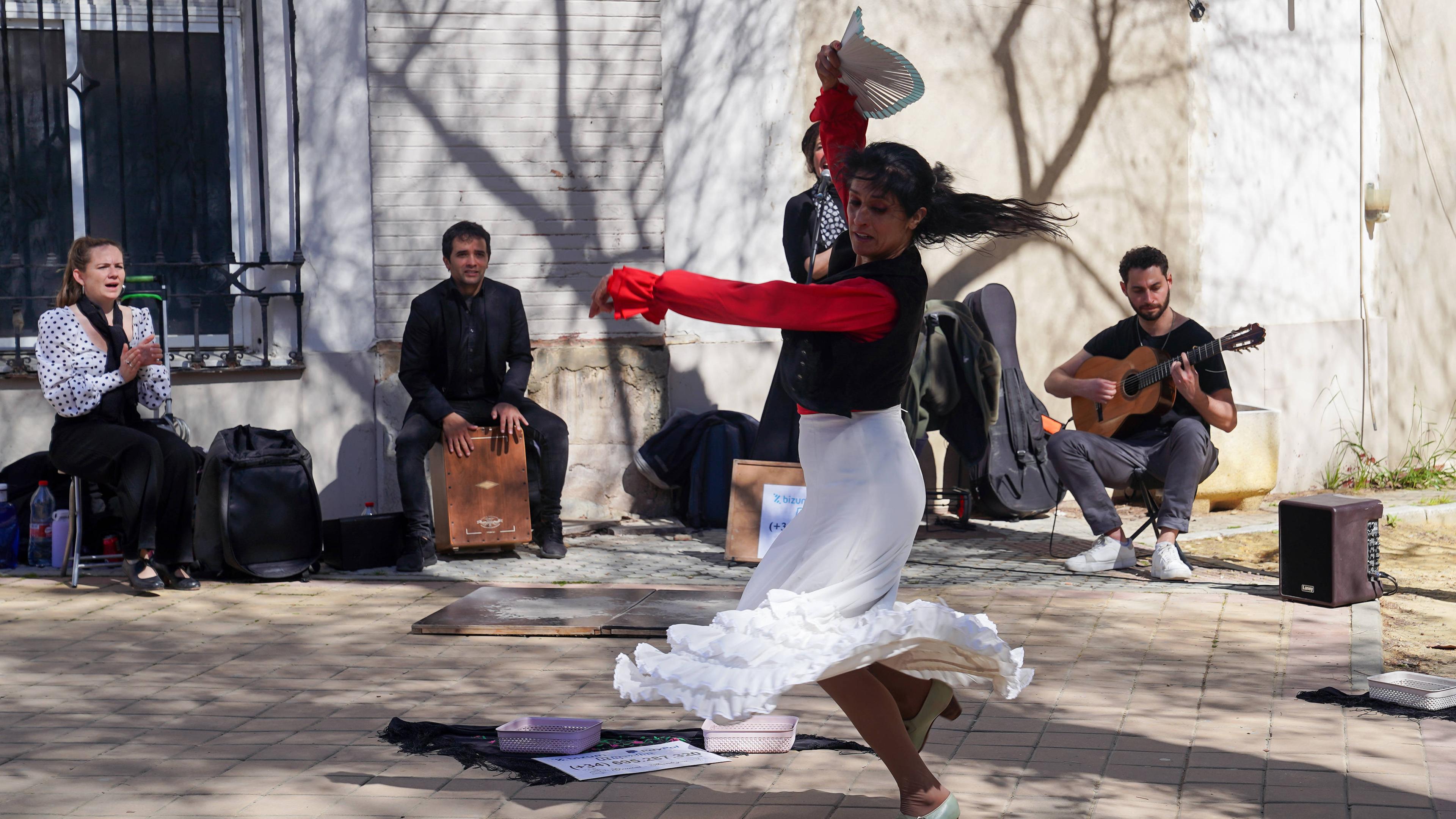 Eine Flamenco-Tänzerin tanzt und hebt dabei ihren Arm mit einem Fächer