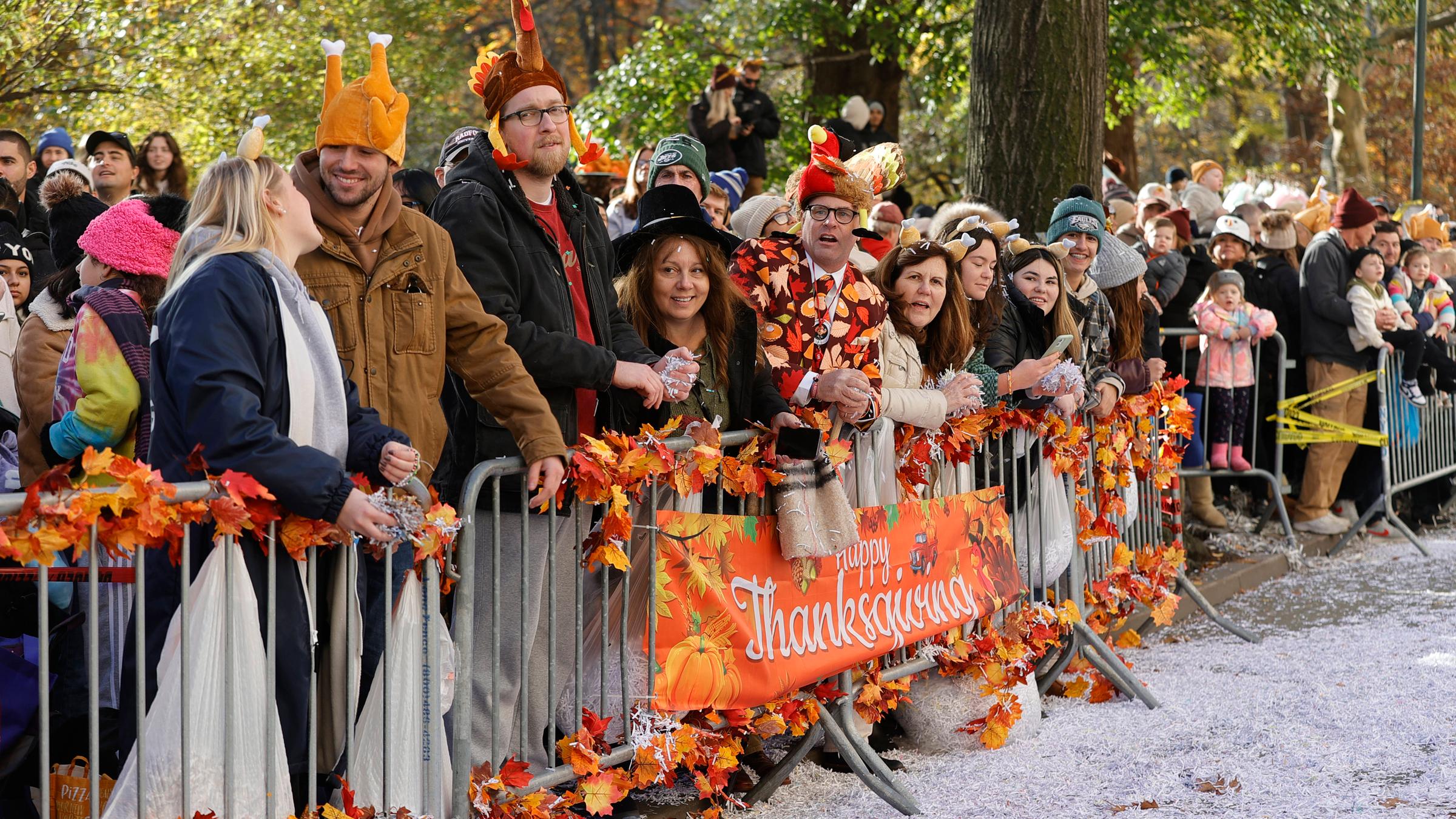 Menschen stehen an einem Geländer mit einem Schild "Happy Thanks Giving"