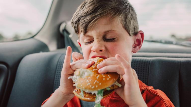 Junge isst einen Burger.
