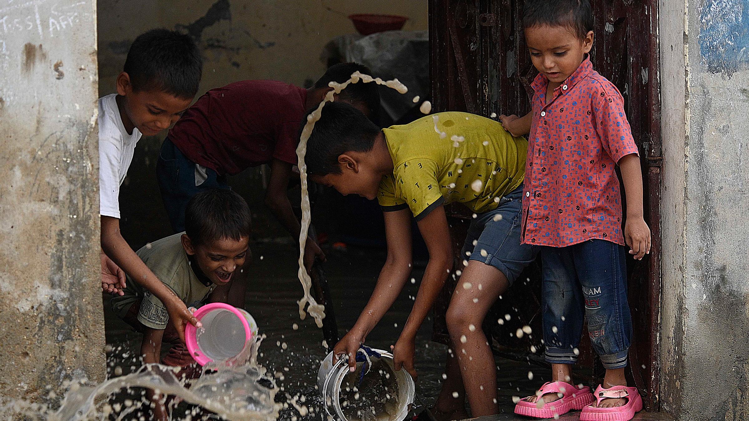Kinder beseitigen am 20. August 2025 Regenwasser aus ihren Häusern nach sintflutartigen Regenfällen in Karatschi, Pakistan.