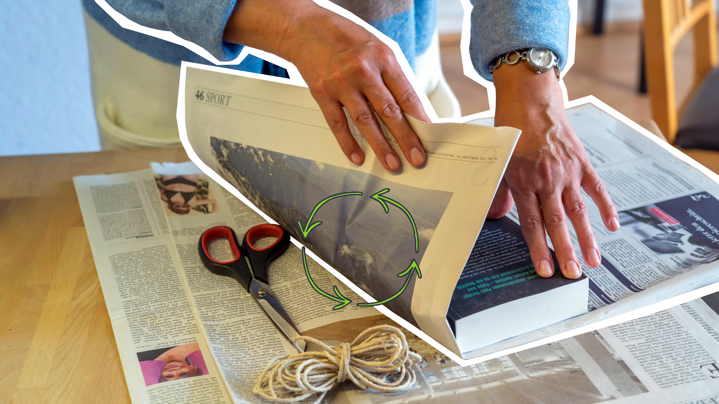 Eine Frau packt ein Buch in Zeitungspapier ein. Auf dem Tisch liegt eine Schere und Kordel. 