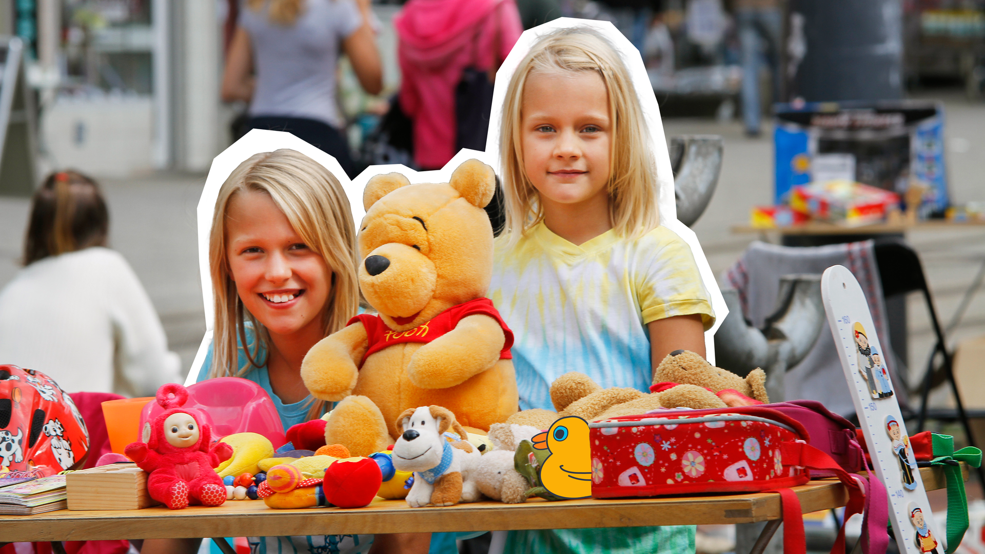 Zwei mädchen, die hinter ihrem verkausstand auf dem Flohmarkt stehen. 
