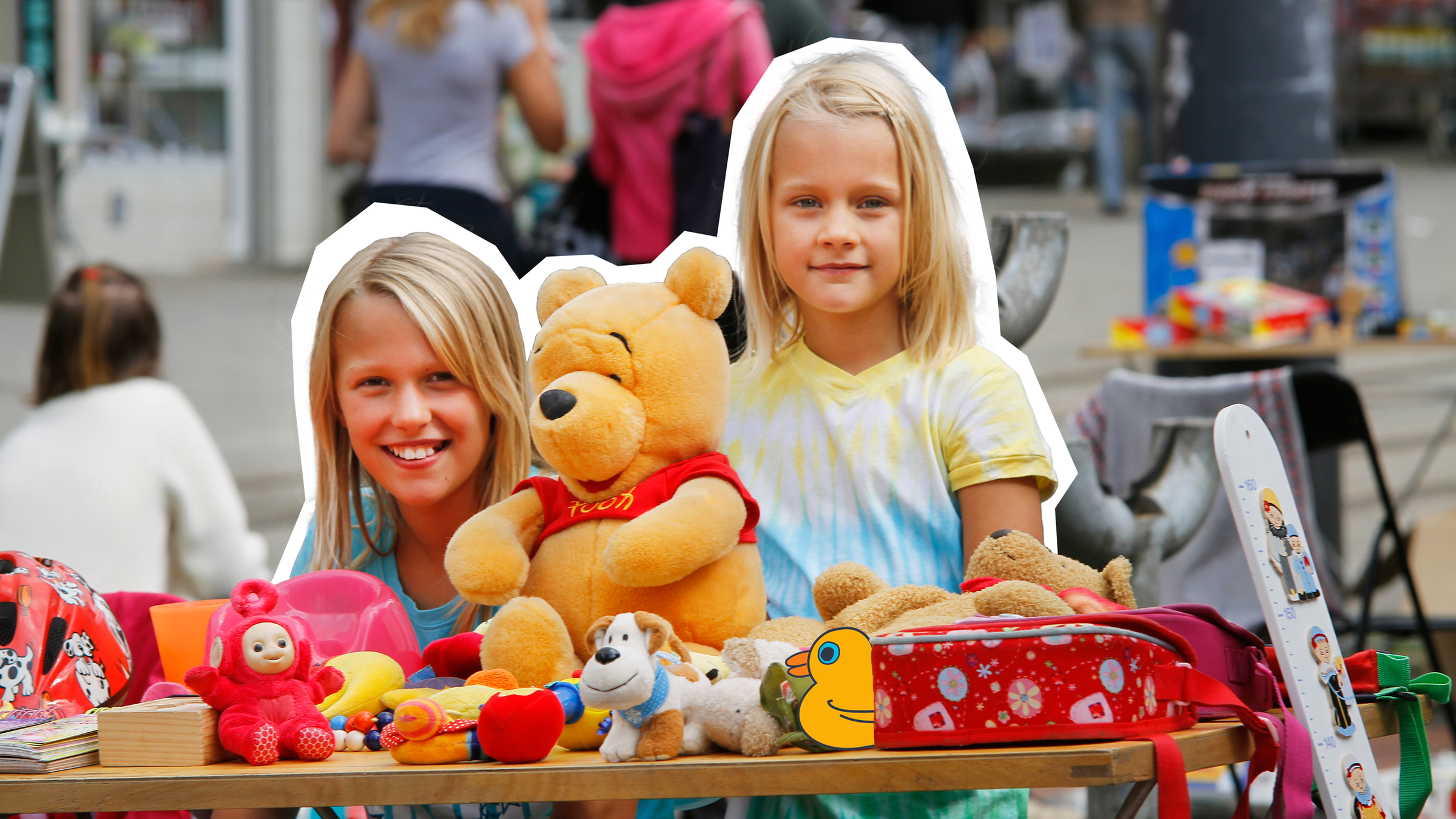 Zwei mädchen, die hinter ihrem verkausstand auf dem Flohmarkt stehen. 