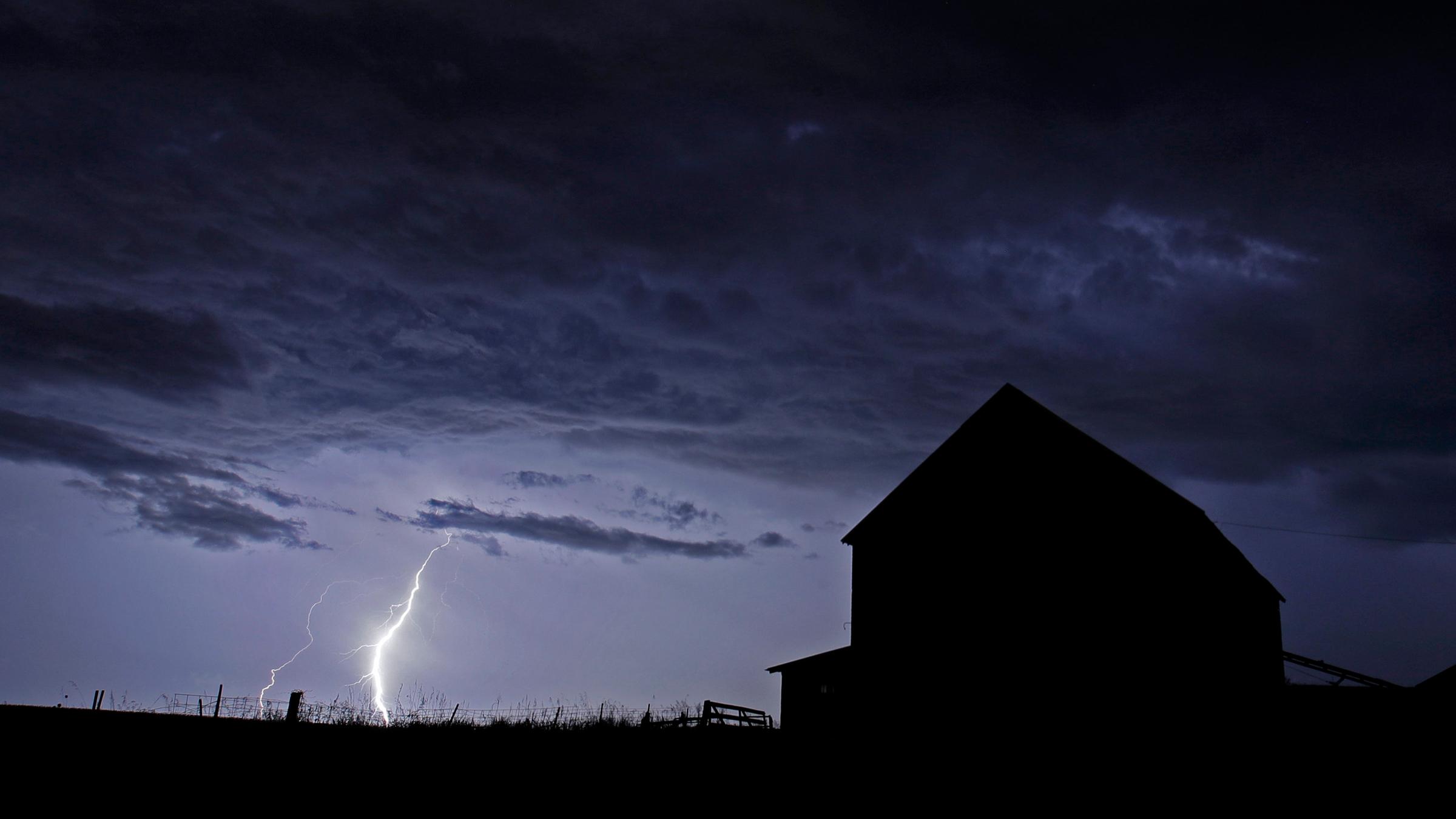 Blitzeinschlag erhellt die Silhouette eines Hauses in Kansas