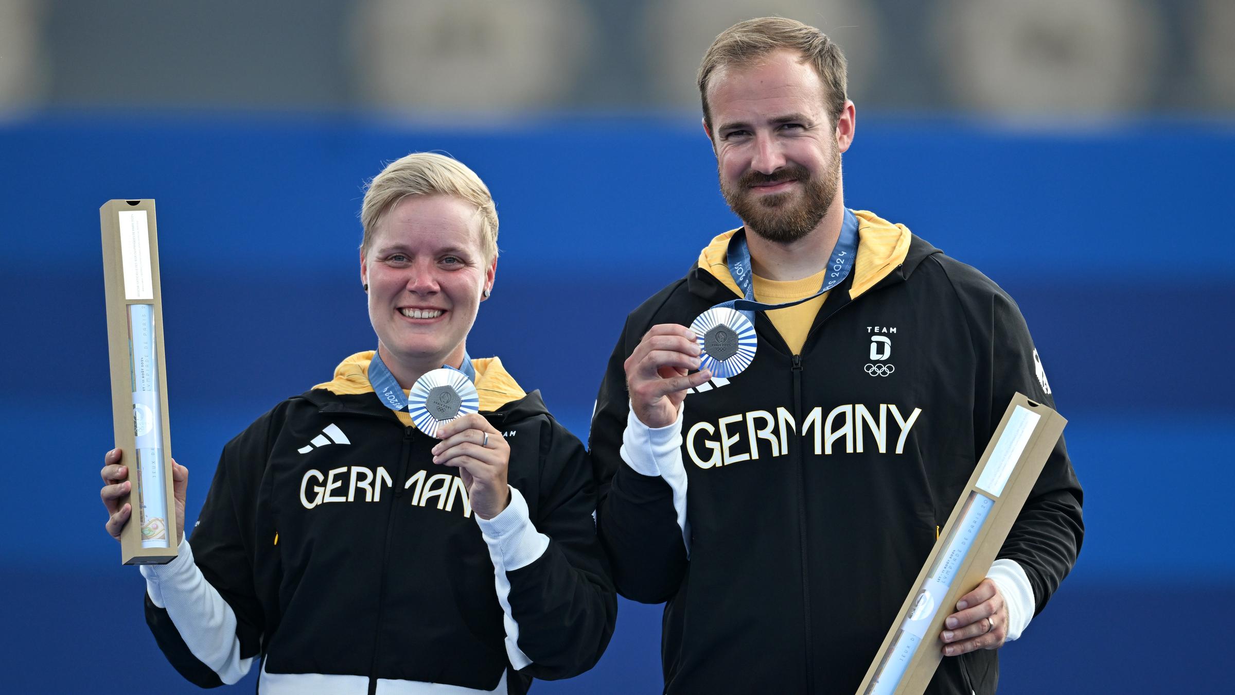 Florian Unruh und Michelle Kroppen halten ihre Silber Medaille in der Hand