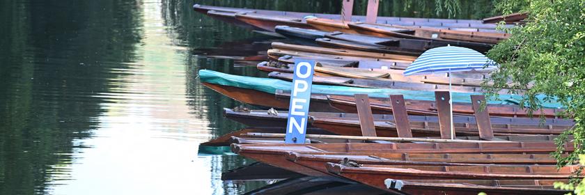 Boote mit "Open"-Schild auf einem Fluss.
