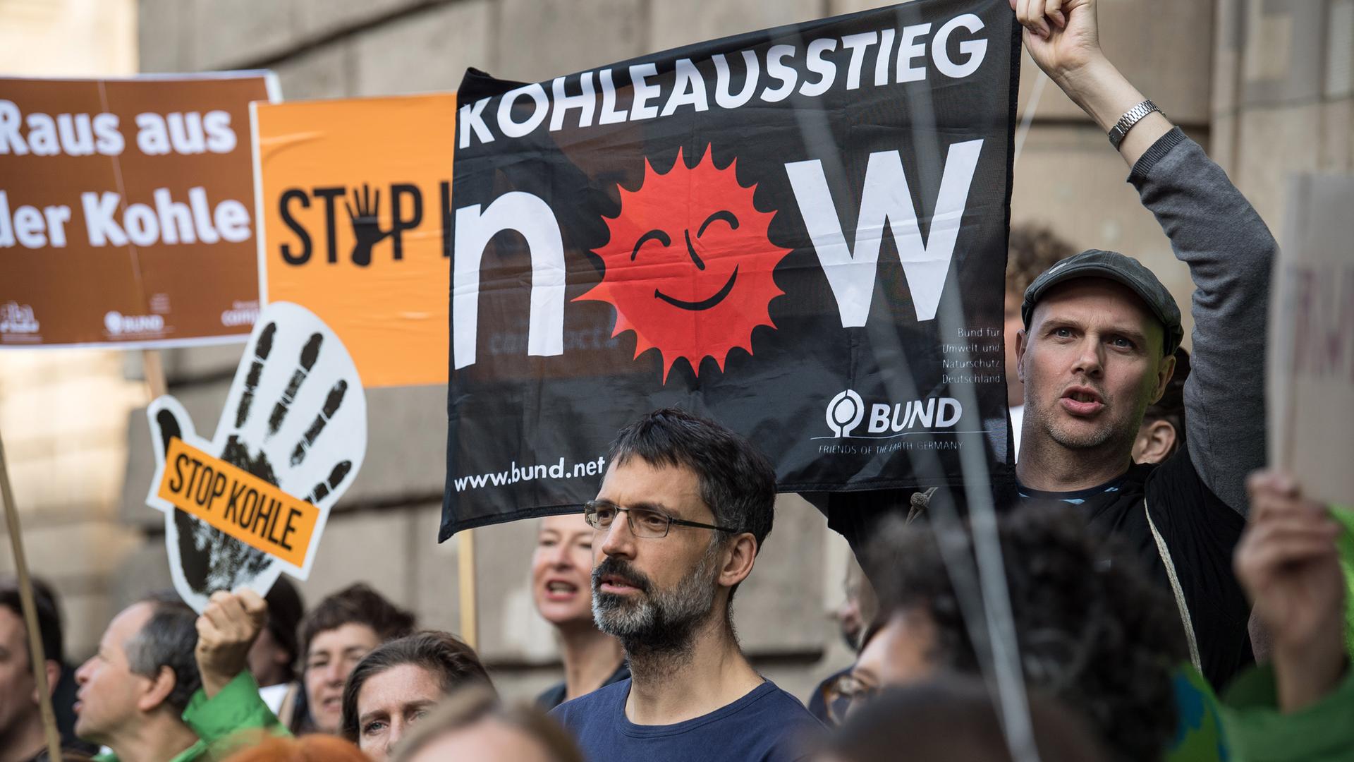 Demonstranten mit Plakaten, auf denen der Ausstieg aus der Kohle gefordert wird.
