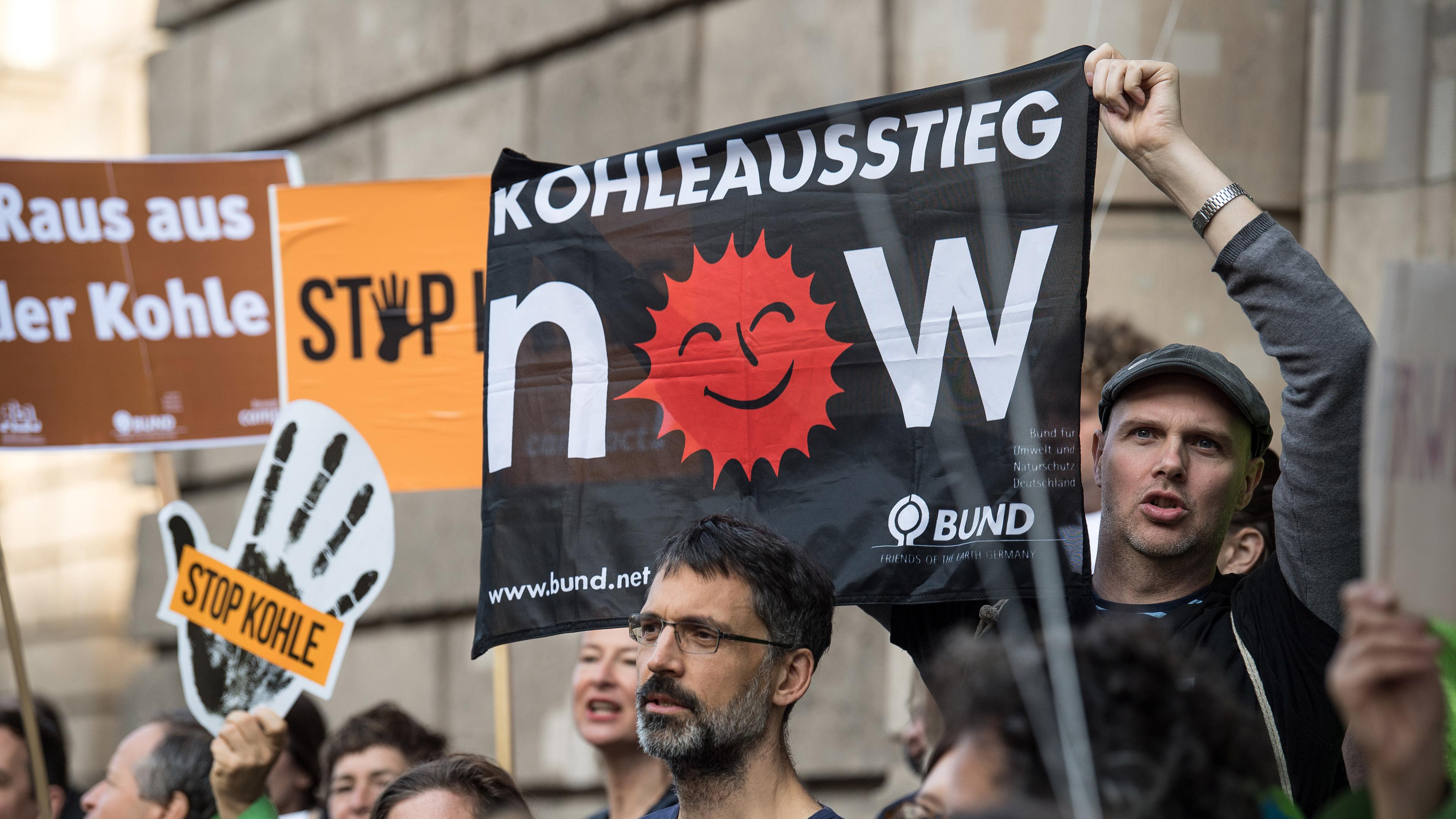 Demonstranten mit Plakaten, auf denen der Ausstieg aus der Kohle gefordert wird.